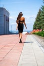 Young beautiful woman in red dress walking on the summer street Royalty Free Stock Photo