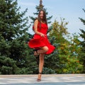 Young beautiful woman in red dress walking on the summer street Royalty Free Stock Photo