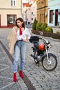 Young beautiful woman in red knitted fabric block heel sock shoes, blue denim jeans pants and teddy jacket coat posing Royalty Free Stock Photo