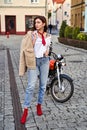 Young beautiful woman in red knitted fabric block heel sock shoes, blue denim jeans pants and teddy jacket coat posing Royalty Free Stock Photo