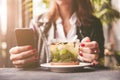 Young beautiful woman with red manicure drinking tea with herbs and lemon in cafe. Close up. Royalty Free Stock Photo