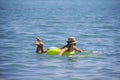 Young beautiful woman is relaxing in blue sea with rubber ring.