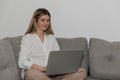 Young beautiful woman relaxing and cits on the sofa using laptop computer. Royalty Free Stock Photo