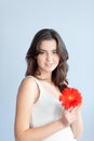 Young beautiful woman relaxing with gerbera flower at spa isolated Royalty Free Stock Photo