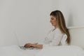 Young beautiful woman relaxing and lies on the bed using laptop computer in the bedroom. Online chat. Working from home. Royalty Free Stock Photo