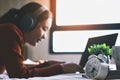 Young beautiful woman relaxing with use headphones listening to music and laptop on bed in the holiday Royalty Free Stock Photo