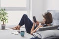 Young beautiful woman resting at home using smart phone. Happy girl texting on her mobile phone online. Royalty Free Stock Photo