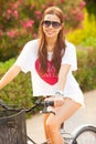 Young beautiful woman riding bicicle on summer