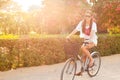 Young beautiful woman riding bicicle on summer