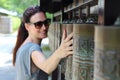 Young beautiful woman rolling buddhist praying cylinders of Kodaiji temple in Kyoto, Japan