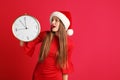 Young beautiful woman in Santa hat holding big clock Royalty Free Stock Photo