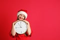 Young beautiful woman in Santa hat holding big clock Royalty Free Stock Photo