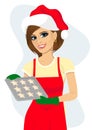 Young beautiful woman in santa hat holding tray with baking cookies Royalty Free Stock Photo