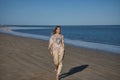 Young and beautiful woman with sequined shirt and bangs, walking on the beach, calm and relaxed, in solitude. Concept beauty,