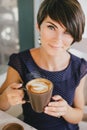 Young beautiful woman with short hair drinking steaming coffee Royalty Free Stock Photo