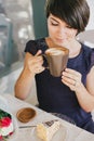 Young beautiful woman with short hair drinking steaming coffee Royalty Free Stock Photo