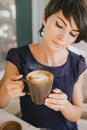 Young beautiful woman with short hair drinking steaming coffee Royalty Free Stock Photo