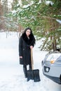 Young beautiful woman shoveling and removing snow from her car, Royalty Free Stock Photo