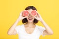 Young beautiful woman showing orange on yellow background Royalty Free Stock Photo