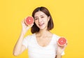 Young beautiful woman showing orange on yellow background Royalty Free Stock Photo