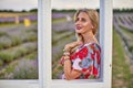 Young beautiful woman sits on a vintage swing in a lavender field Royalty Free Stock Photo