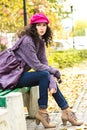 Young beautiful woman sitting on a bench in a city park Royalty Free Stock Photo