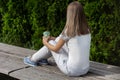 Girl sitting on bench with striped pants and holding cup of coffee. Girl resting in the park on good weather Royalty Free Stock Photo