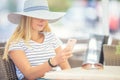 Young beautiful woman sitting in cafe and using smartphone