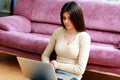 Young beautiful woman sitting on the floor with laptop Royalty Free Stock Photo