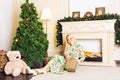 Young beautiful woman sitting on floor near christmas tree and presents on a new year eve. Interior with christmas Royalty Free Stock Photo