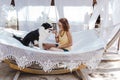 Young beautiful woman sitting on hammock with her border collie dog outdoors. Fun and summer lifestyle Royalty Free Stock Photo