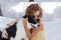 Young beautiful woman sitting on hammock with her border collie dog outdoors. Fun and summer lifestyle Royalty Free Stock Photo