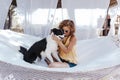 Young beautiful woman sitting on hammock with her border collie dog outdoors. Fun and summer lifestyle Royalty Free Stock Photo