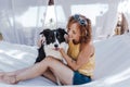 Young beautiful woman sitting on hammock with her border collie dog outdoors. Fun and summer lifestyle Royalty Free Stock Photo