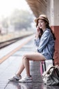 young beautiful woman is sitting on luggage and using a smartpho Royalty Free Stock Photo