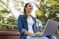 Young beautiful woman sitting outdoors using laptop computer. Royalty Free Stock Photo