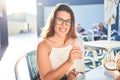 Young beautiful woman sitting at restaurant enjoying summer vacation drinking a bottle of water Royalty Free Stock Photo