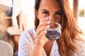 Young beautiful woman sitting at restaurant enjoying summer vacation drinking a glass of water Royalty Free Stock Photo