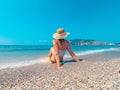 Young beautiful woman is sitting on the sea cost and enjoying waves landscape. Alanya, Turkey