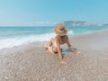 Young beautiful woman is sitting on the sea cost and enjoying waves landscape. Alanya, Turkey