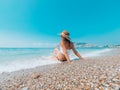 Young beautiful woman is sitting on the sea cost and enjoying waves landscape. Alanya, Turkey