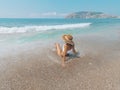 Young beautiful woman is sitting on the sea cost and enjoying waves landscape. Alanya, Turkey