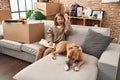 Young beautiful woman sitting on the sofa at new home annoyed and frustrated shouting with anger, yelling crazy with anger and Royalty Free Stock Photo