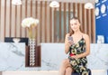 Young beautiful woman sitting on suitcases at the front desk hotel reception, Female with bag travel luggage at the reception