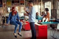 A young beautiful woman is sitting on the swing and enjoying a talk with her colleague in the office Royalty Free Stock Photo