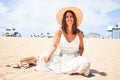 Young beautiful woman smiling happy enjoying summer vacation at the beach sitting on the sun Royalty Free Stock Photo