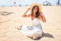 Young beautiful woman smiling happy enjoying summer vacation at the beach sitting on the sun Royalty Free Stock Photo