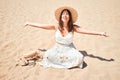 Young beautiful woman smiling happy enjoying summer vacation at the beach sitting on the sun sunbathing with open arms Royalty Free Stock Photo