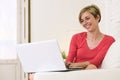 Young beautiful woman smiling happy working at home with laptop computer on sofa couch Royalty Free Stock Photo