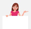 Young beautiful woman smiling and holding a blank / empty sheet of white paper or board & gesturing hand to copy space. Royalty Free Stock Photo